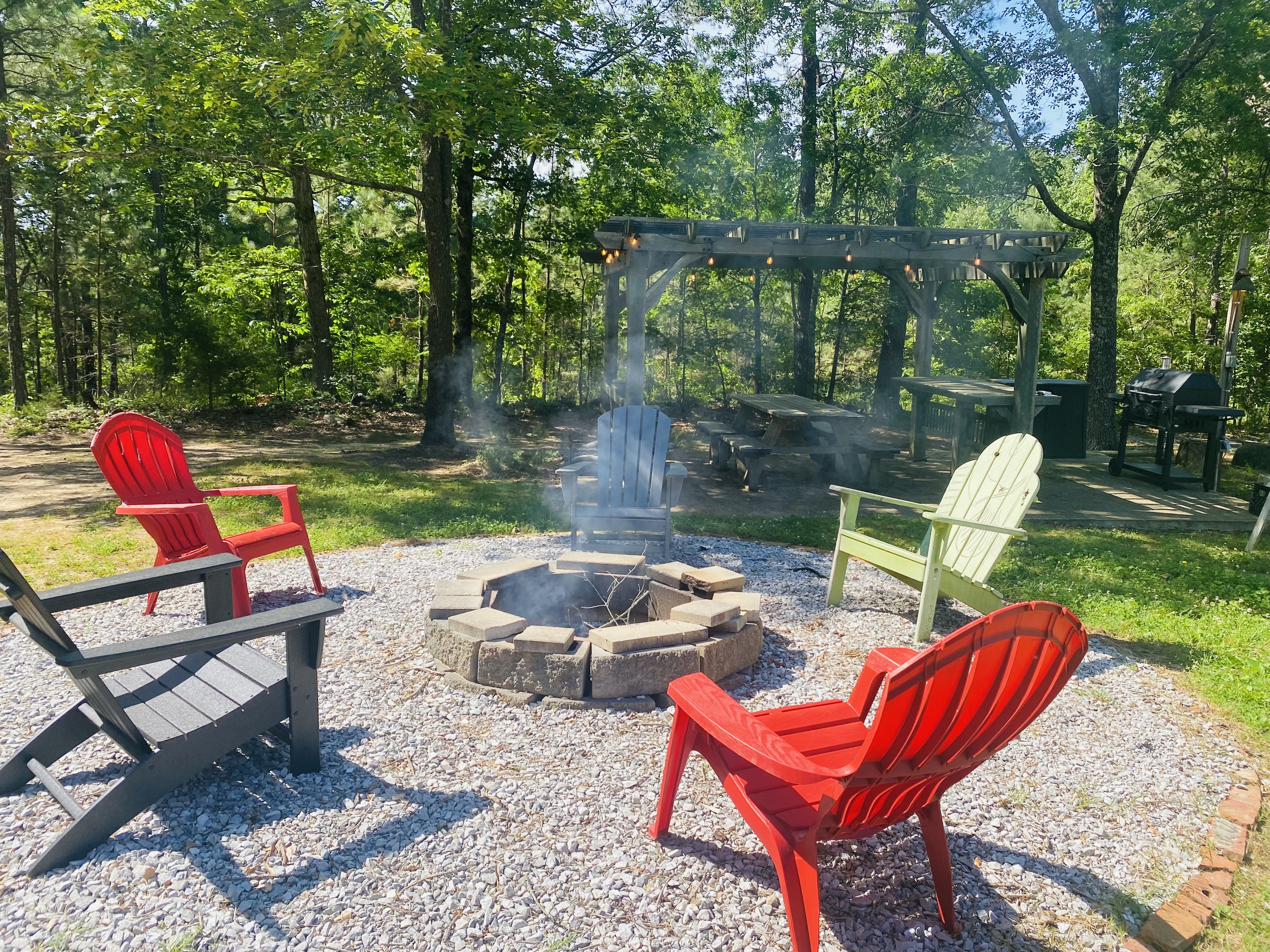 Afternoon fire pit gathering with chairs and string lights